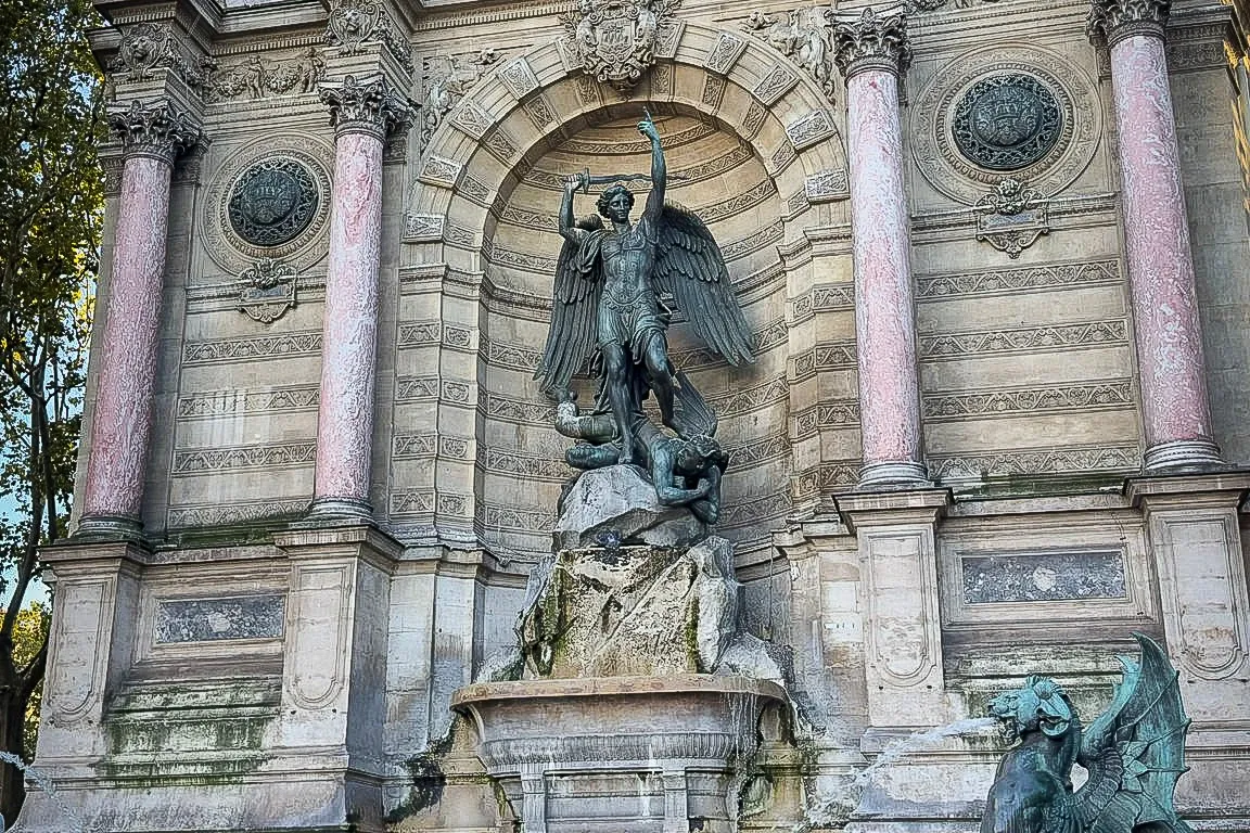 Fontaine Saint-Michel in Paris, a large stone fountain with a central sculpture of Archangel Michael slaying a dragon, sur...