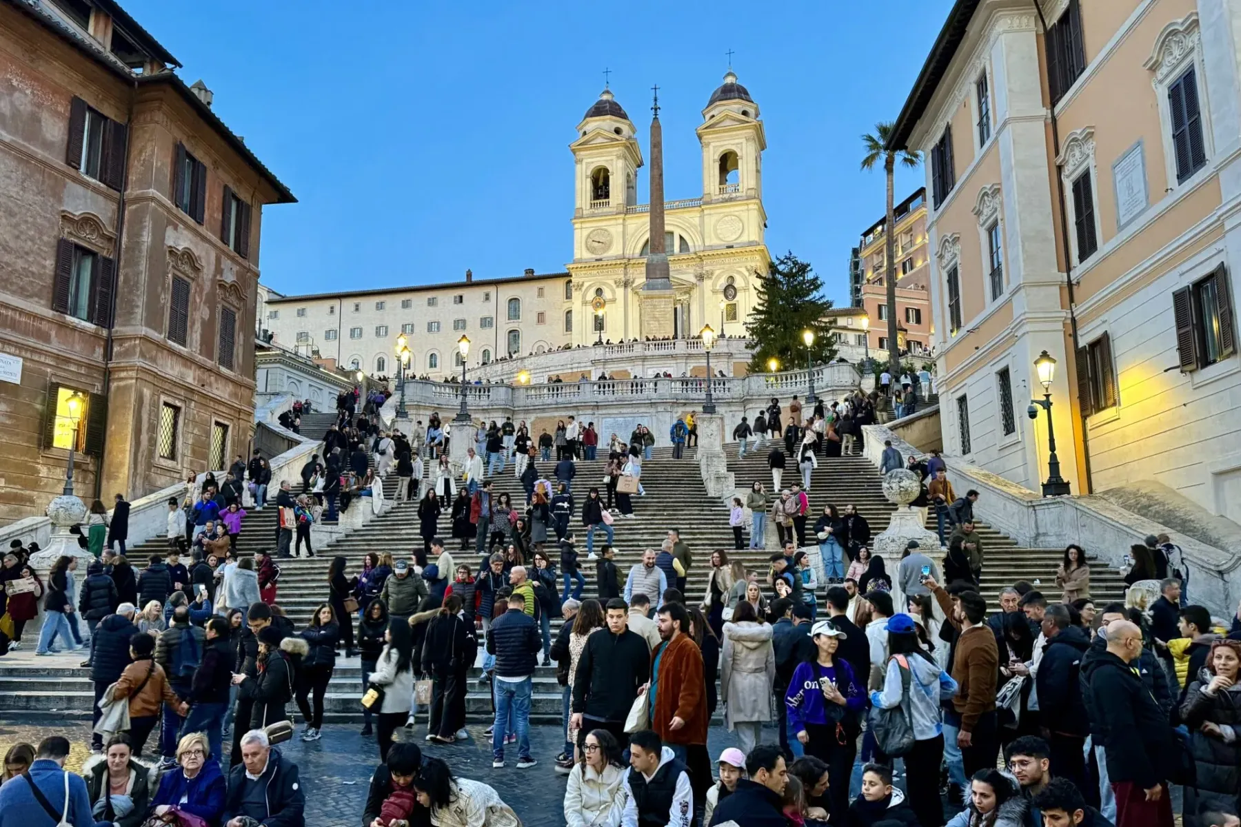 Tourists enjoying the Spanish Steps in Rome at dusk.