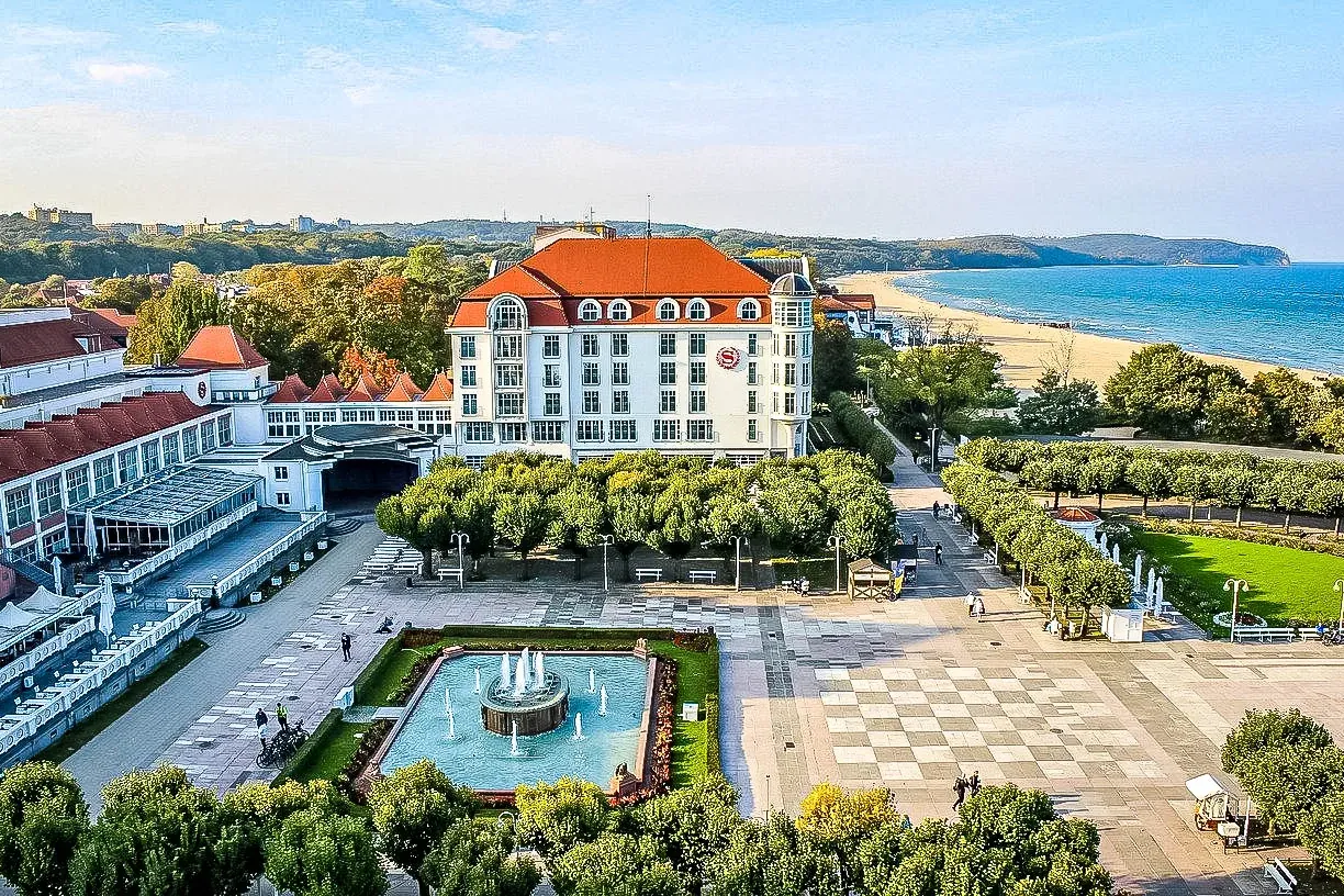 Aerial view of Sopot's Grand Hotel, beach, and fountain.