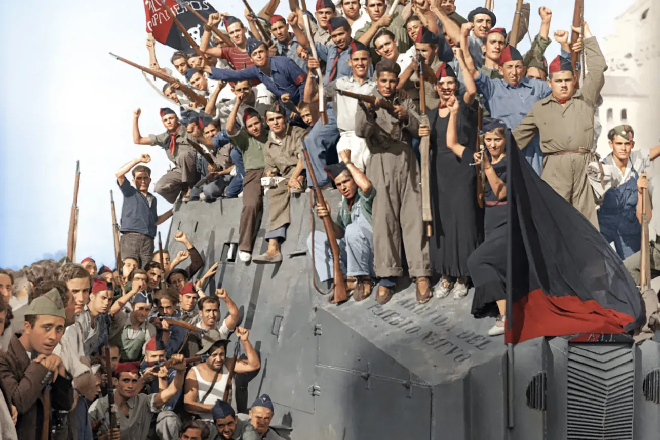 Crowd of civilians, some armed with rifles, on and around an improvised armored vehicle in a city street, holding red and ...