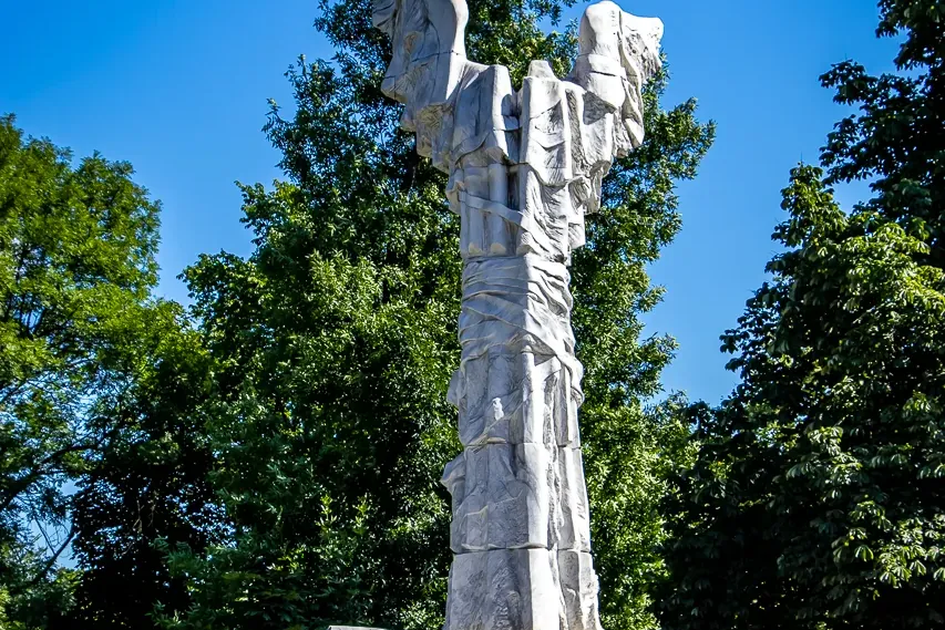 Tall, light-colored stone monument dedicated to Monte Cassino, with an eagle symbol and 'MAJ 1944' on its base, against a ...