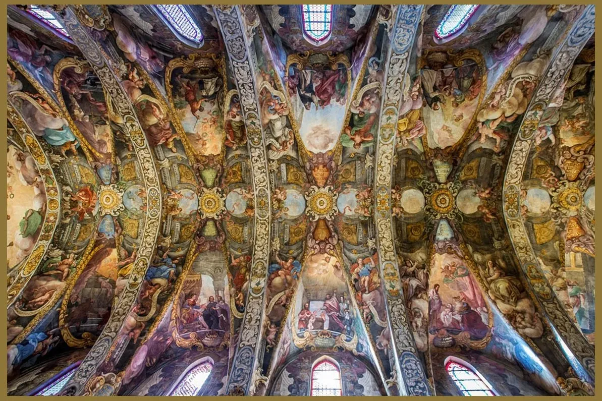 The ornate, frescoed vaulted ceilings of the Church of San Nicolás in Valencia, depicting religious scenes.
