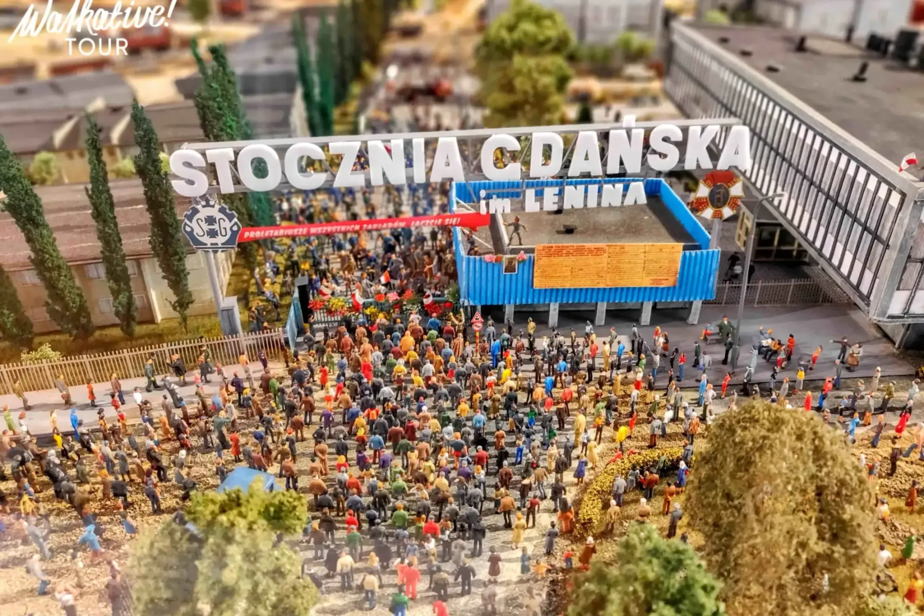 Miniature model of the Gdańsk Shipyard, showing a large crowd of people gathered under a sign "STOCZNIA GDAŃSKA im. LENINA".