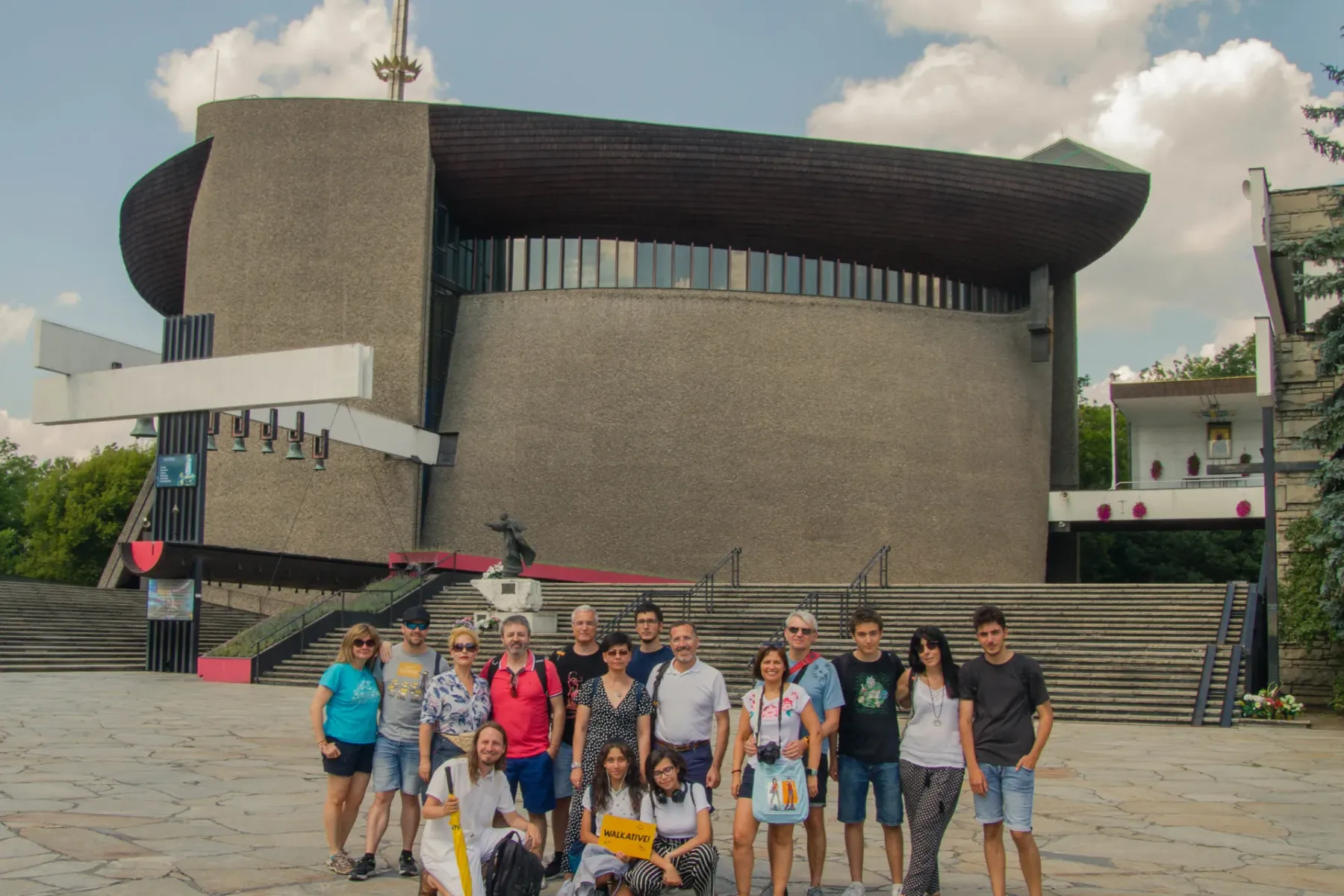 A Walkative tour group poses for a photo in front of the modern Lord's Ark church (Arka Pana) in Nowa Huta, Krakow.