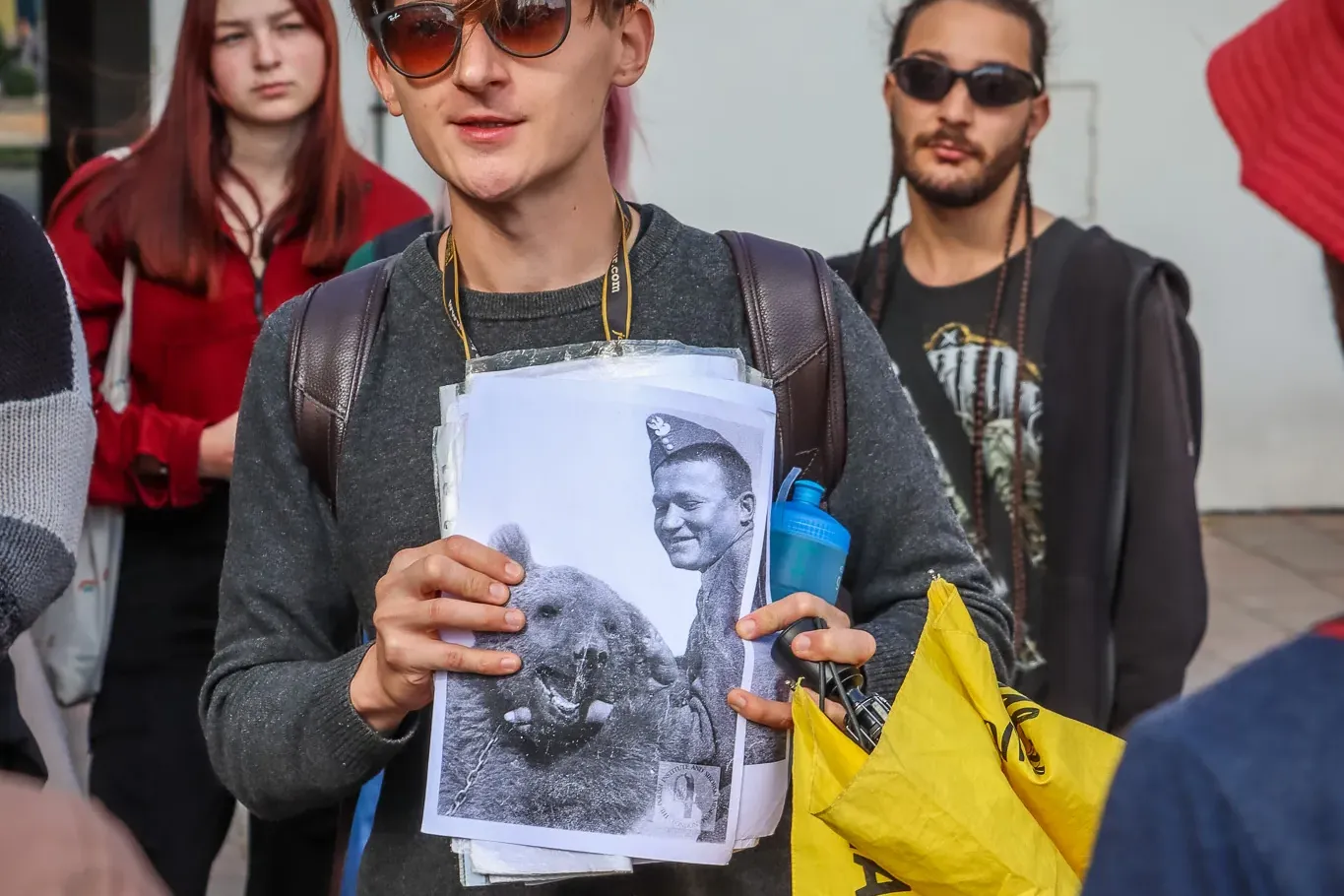 A tour guide shows a group a historical photo of a Polish soldier with Wojtek the Bear during a walking tour in Krakow.