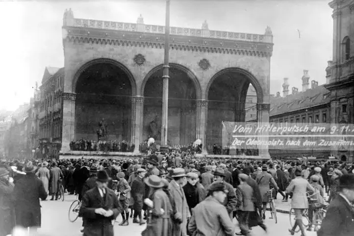 Black and white historical photo of a large crowd gathered in front of the Feldherrnhalle at Odeonsplatz in Munich.