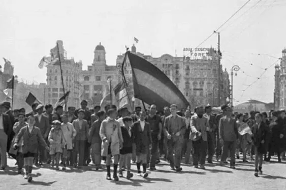 A black and white historical photo of a demonstration in Valencia with flags of the Second Spanish Republic.