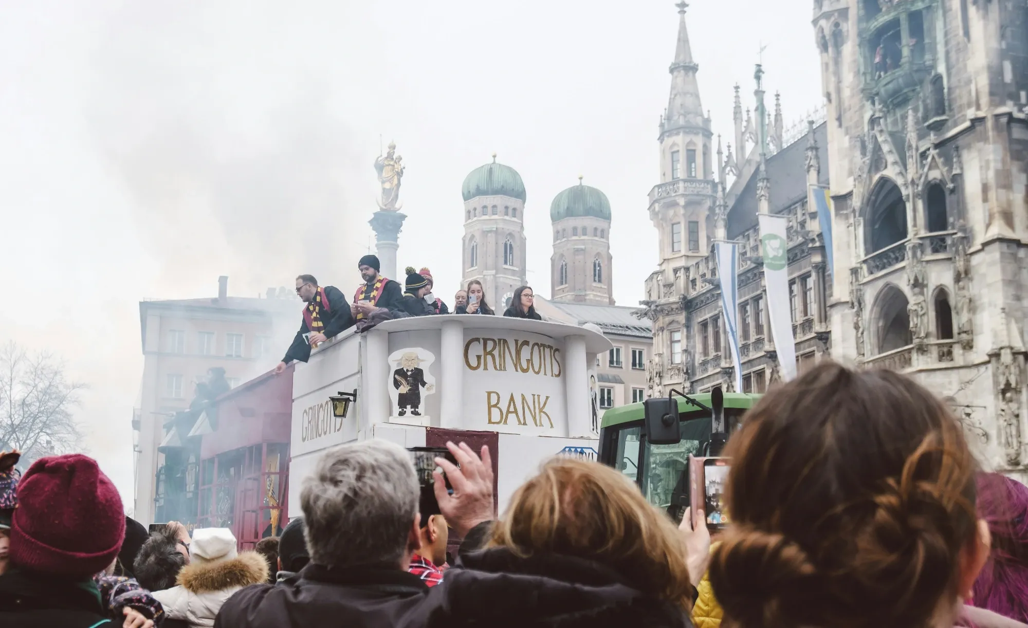 Munich's main carnival procession on Marienplatz with the Frauenkirche towers visible in the background.