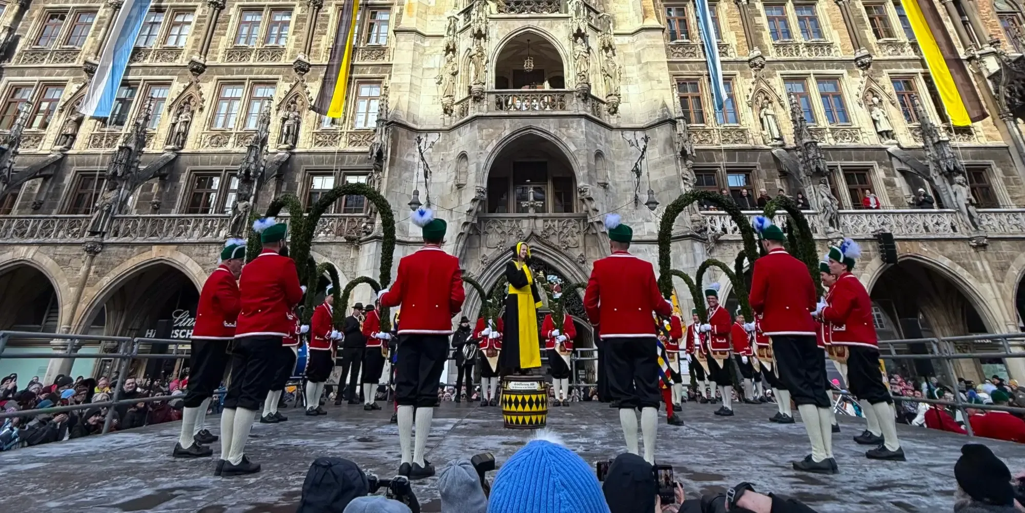 Traditional performance (Schäfflertanz) in front of Munich's New Town Hall. The Munich Child, a young woman in a black and ye