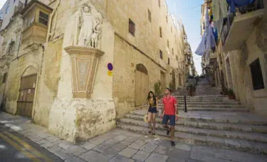 Couple walking down stairs in Valletta, Malta.