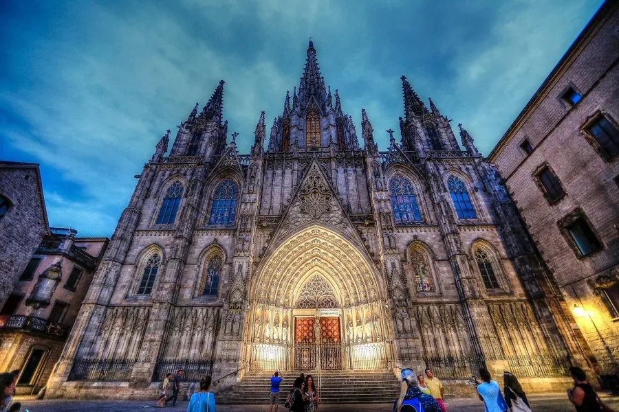 Barcelona Cathedral at dusk, tourists admiring the Gothic architecture.