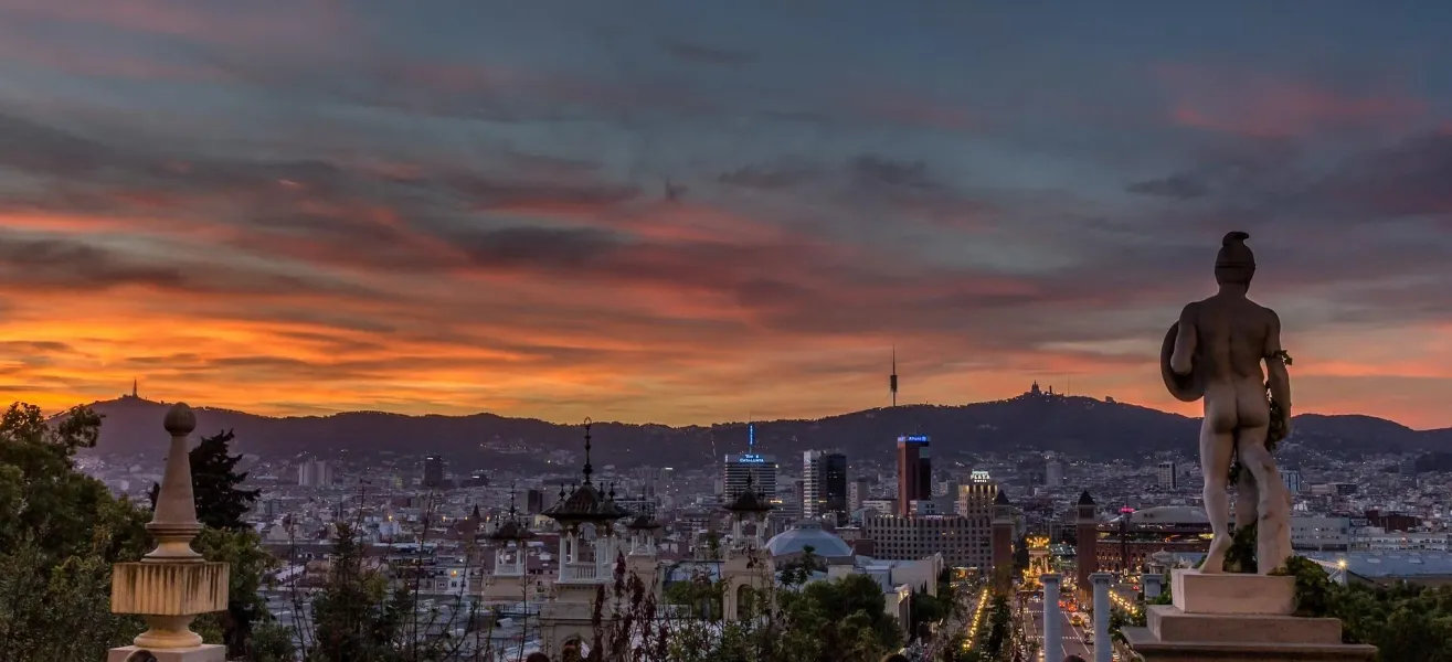 Barcelona skyline at sunset with statue.