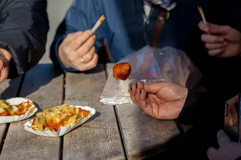Tourists enjoying Currywurst in Berlin.