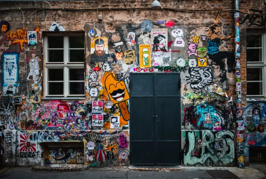 Colorful graffiti and street art cover a building wall in Berlin.