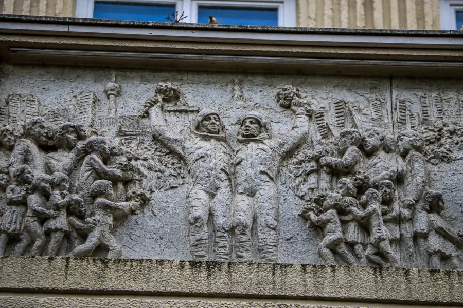Stone relief in Berlin depicting cosmonauts and children.
