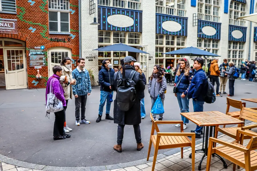 A guided tour group in a Berlin courtyard.
