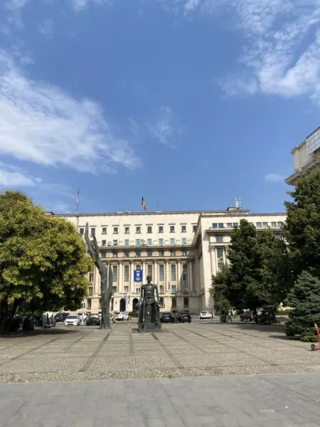 The Palace of the Parliament in Bucharest, Romania, with sculptures in the foreground.