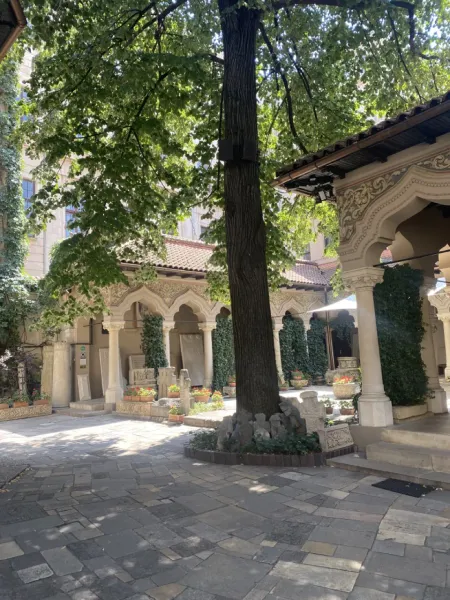 Tranquil courtyard of a historic Romanian monastery in Bucharest.