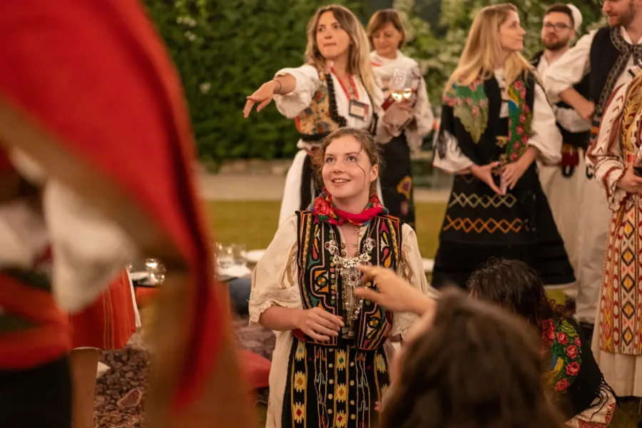 Tourists experience Romanian culture, wearing traditional clothing.