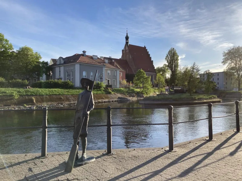 A bronze statue by a canal in Bydgoszcz's Old Town, Poland.
