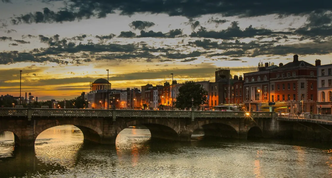 Sunset view of Dublin's cityscape with a bridge over the River Liffey.