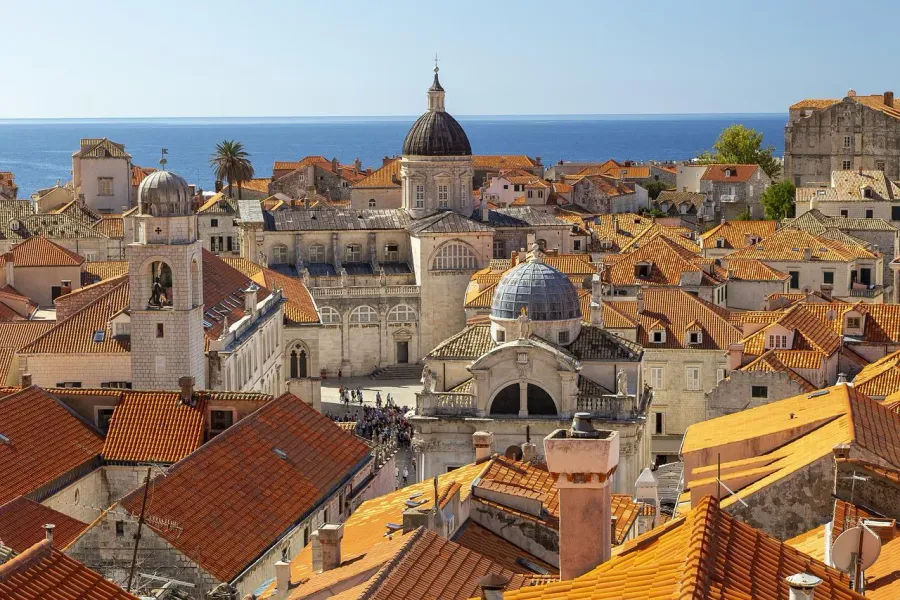 Aerial view of Dubrovnik's Old Town with terracotta roofs and the Adriatic Sea.