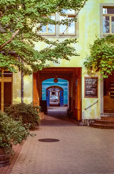 Picturesque archway leading to a hidden courtyard cafe in Germany.
