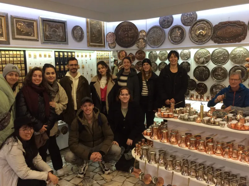 Happy tour group in an Istanbul shop, surrounded by beautiful copperware.