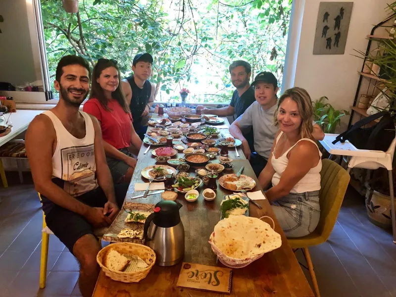 Happy tourists enjoying a delicious Turkish breakfast together in Istanbul.