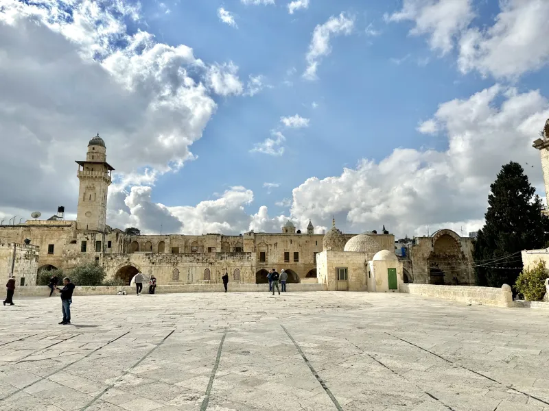 Tourists exploring the serene courtyard of the Temple Mount in Jerusalem.