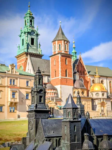 Bronze model of Wawel Cathedral in Krakow, Poland, with the real cathedral blurred in the background.