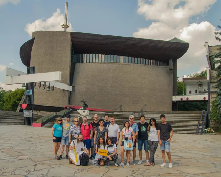 A happy tour group poses in front of the Sanctuary of Divine Mercy in Krakow, Poland.