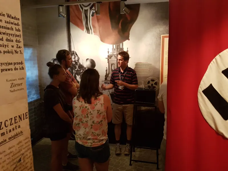 A guided tour group in a Krakow museum, learning about history.