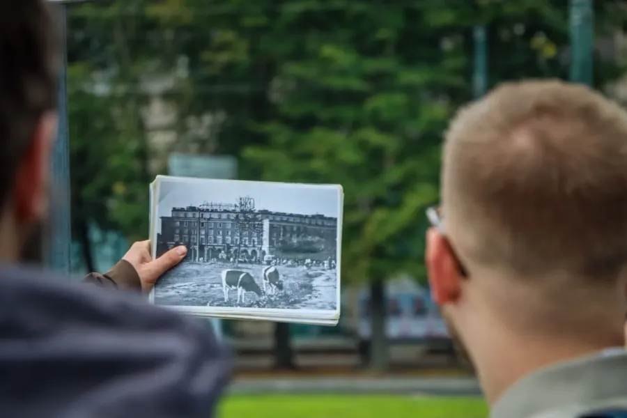 A guided tour in Krakow, Poland, showing a historical photo of a building.
