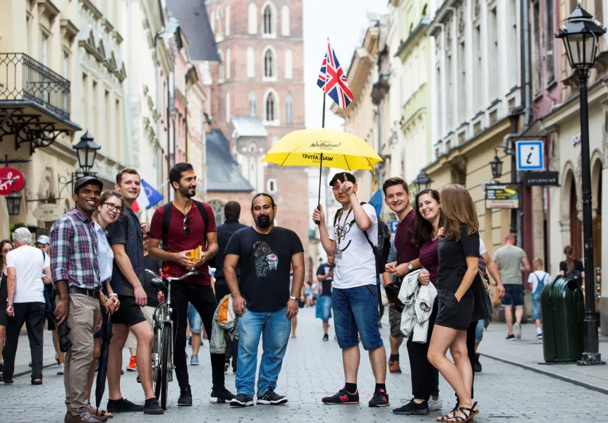 Happy tourists on a guided walking tour in Krakow's Old Town.
