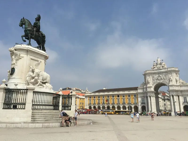 Tourists exploring Praça do Comércio in Lisbon, Portugal.