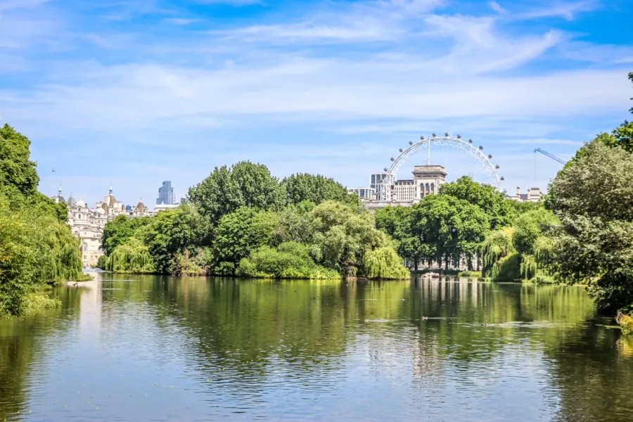 Serene view of St. James's Park in London, with the London Eye in the distance.