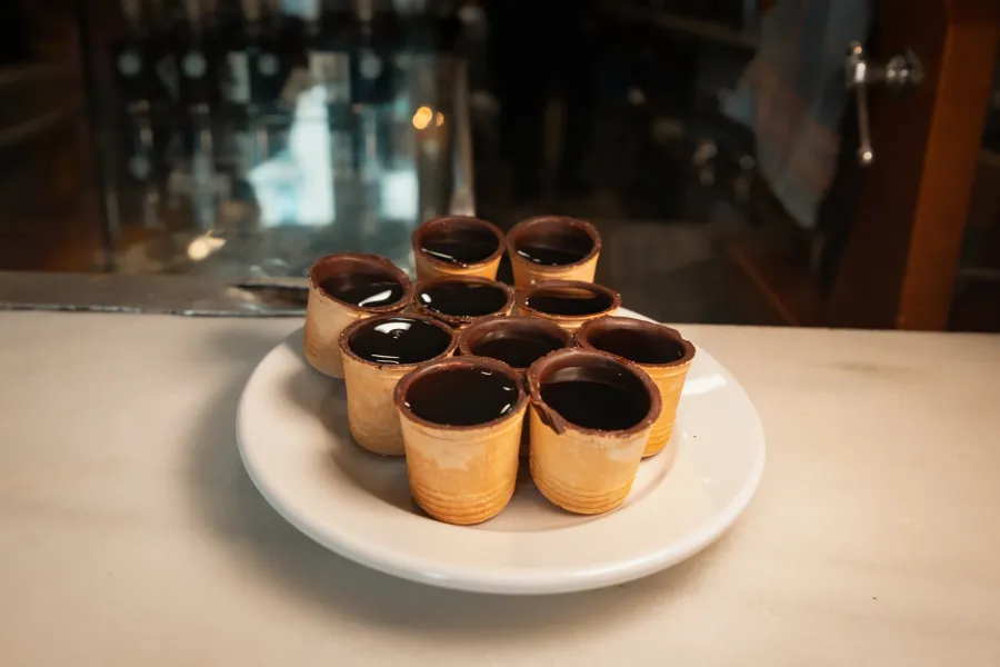 Chocolate-dipped waffle cups filled with a dark liquid in Madrid.