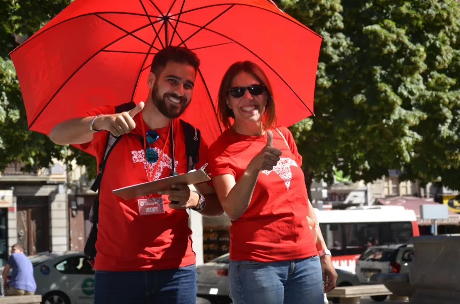 Two smiling tour guides in Madrid give thumbs up.