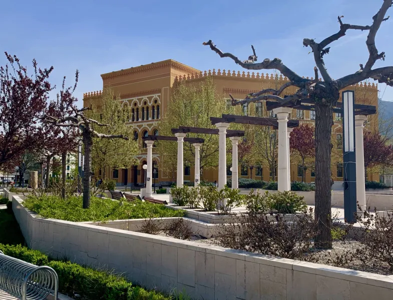 Serene park in Mostar, featuring a beautiful yellow building.