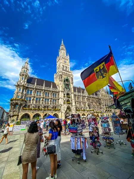 Tourists explore Marienplatz in Munich, Germany, with the iconic New Town Hall in the background.
