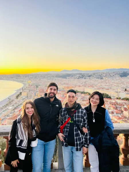 Happy tourists enjoying a stunning sunset view of Nice, France.