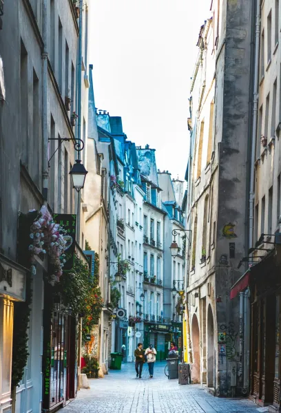 A charming Parisian alleyway with two people walking.