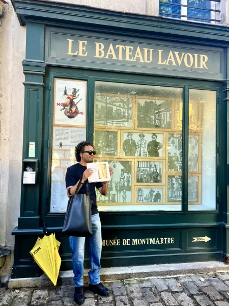 A tourist explores Montmartre, Paris, standing outside Le Bateau Lavoir, a historic building.