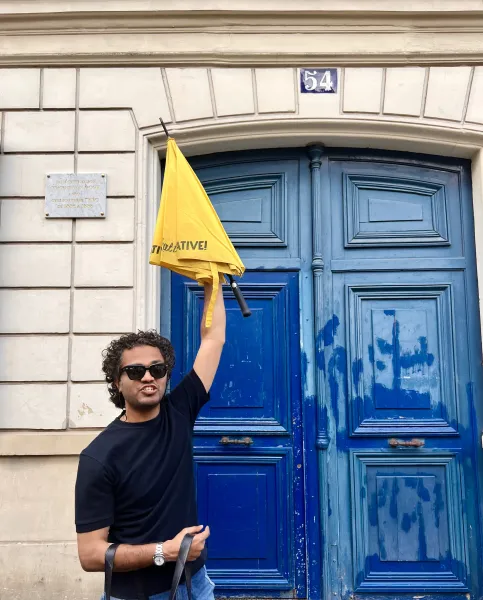A tour guide in Paris holds up a yellow umbrella outside a building where Vincent van Gogh once lived.