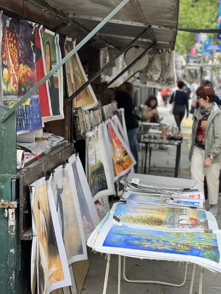 Colorful paintings on display at a Parisian street art market.
