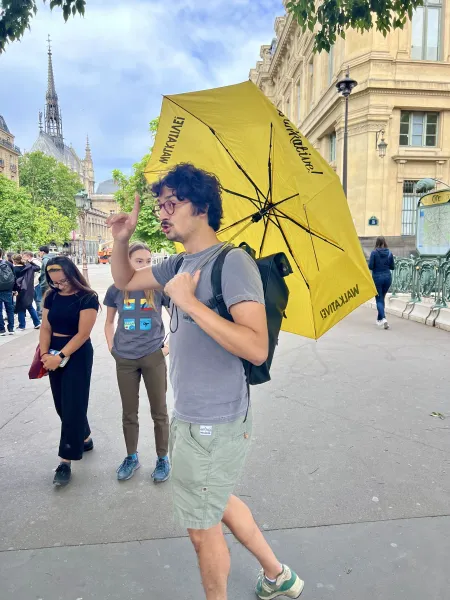 A tour guide leads a small group on a walking tour in Paris, France, near the Sainte-Chapelle.