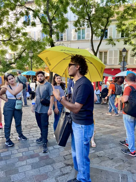 A tour guide leads a small group on a walking tour in Paris.