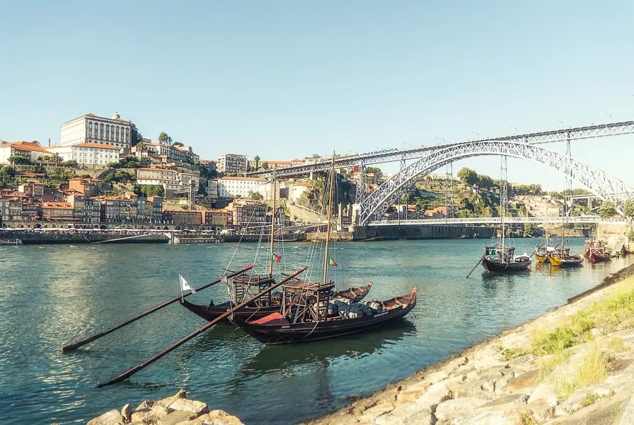 Traditional rabelo boats on the Douro River in Porto, Portugal, with the Dom Luís I Bridge in the background.