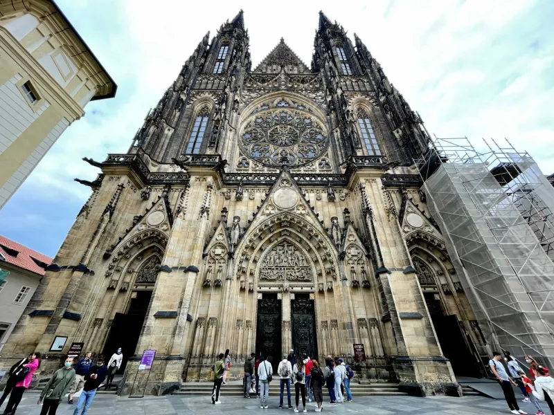 A tour group stands before the magnificent St. Vitus Cathedral in Prague Castle.
